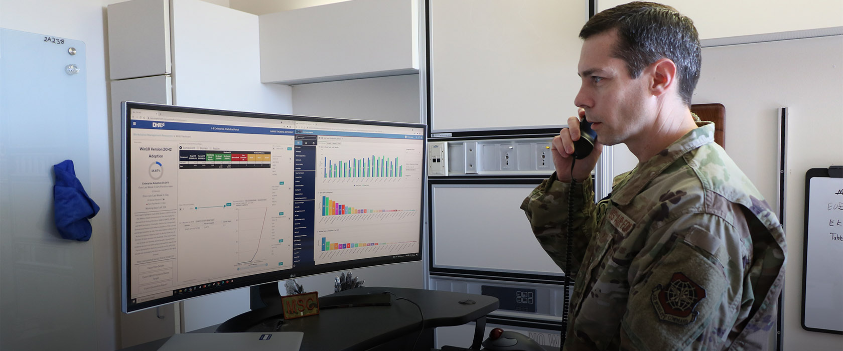airman on the phone looking at a computer screen